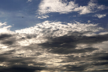 The Airplane flying over the nimbus clouds in the blue sky backgrounds