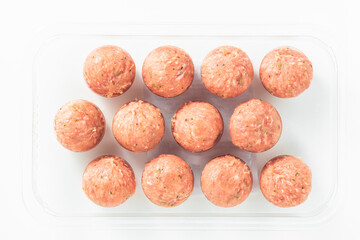 uncooked meatballs on white. product concept