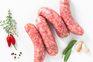 uncooked homemade sausages with aromatic herbs, hot pepper and garlic on white