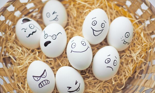 Easter eggs with different facial expressions in basket