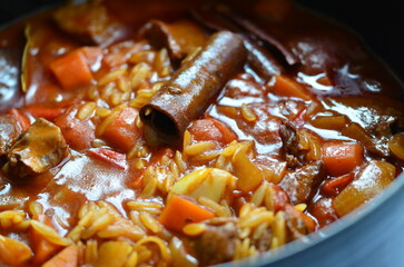 rice with meat and vegetables in a frying pan on a wooden background