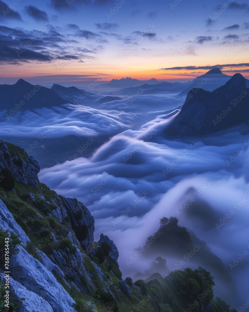 Poster the sun sets casting a warm glow over the horizon with soft clouds blanketing the rugged mountain te