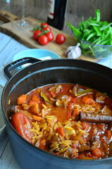 rice with meat and vegetables in a frying pan on a wooden background