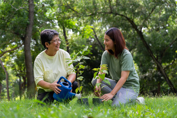 Naklejka na ściany i meble Old Asian Women and daughter join as volunteers for reforestation, earth conservation activities for reduce global warming growth feature and take care nature earth. Environment Concept