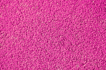 Textured pink background, rubber coating for stadiums, running tracks, tennis courts. Top view, close-up