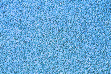 Textured blue background, rubber coating for stadiums, running tracks, tennis courts. Top view, close-up