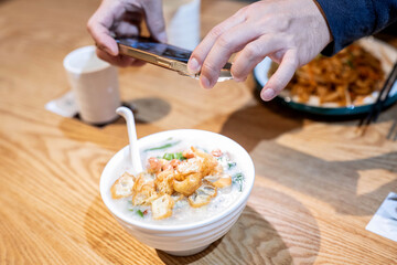 Obraz na płótnie Canvas Take photos of gourmet snacks Tingzi porridge with your mobile phone