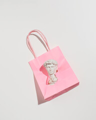 Bust of a beautiful man in Renaissance style, composition with shopping paper bag, Italian aesthetics.