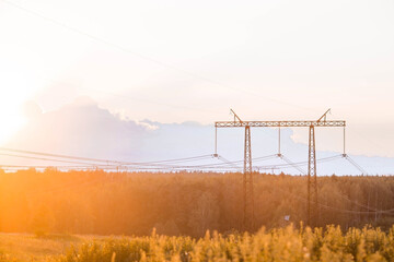 Power transmission lines (power lines) on steel supports against the background of the evening...