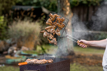Barbecue at the cottage. May holidays. Barbecue in nature. The process of cooking meat on the...