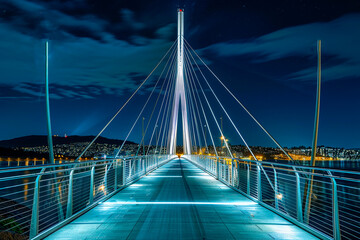Illuminated bridge spanning river at night