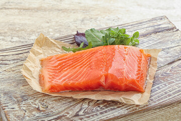 Raw salmon fillet over board