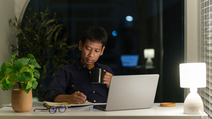 Focused businessman working overtime in an office at night.