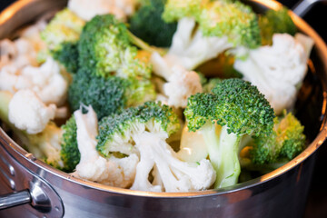 Broccoli and cauliflower are steamed in a saucepan - healthy diet, baby food, cooking in a steamer	
