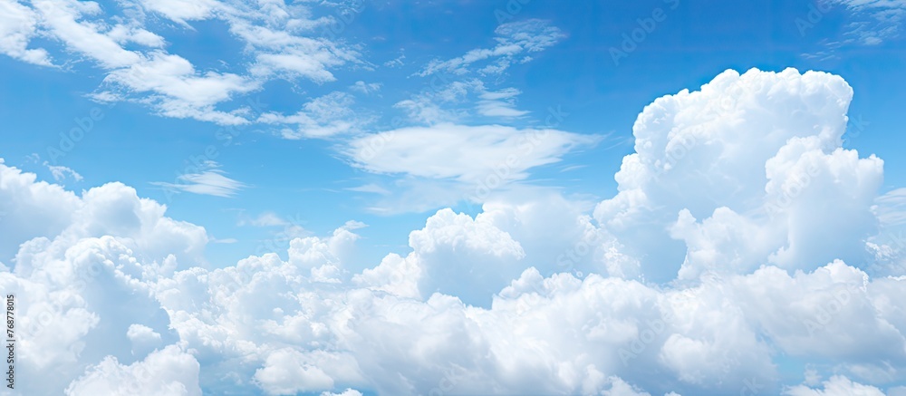 Poster numerous voluminous cumulus clouds float in the sky over the tranquil water surface, creating a pict