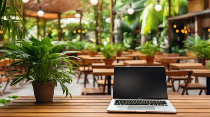 Fototapeta na wymiar Laptop with blank screen on wooden table in cafe. Mockup