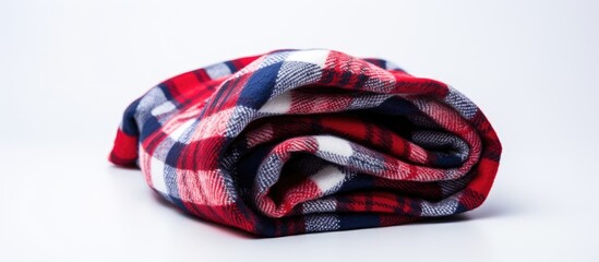 A close up view of a woolen checkered plaid blanket in red and blue colors neatly folded on a clean white surface
