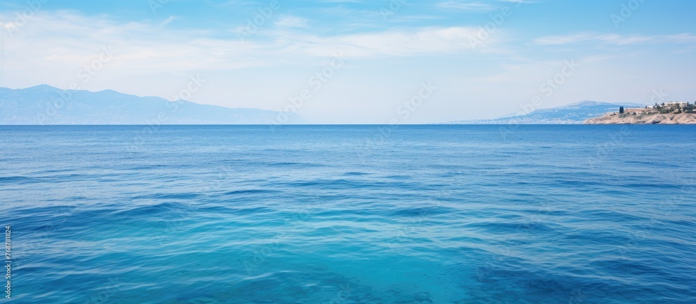 Aufkleber a serene view of a vast blue ocean stretching out towards towering distant mountains