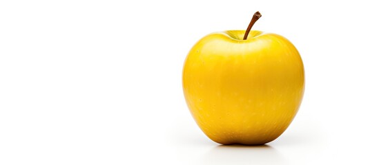 Obraz premium A single yellow apple rests on the clean white surface