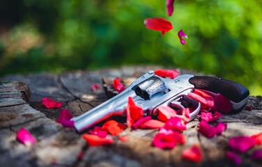 Red petals falling on an old revolver 