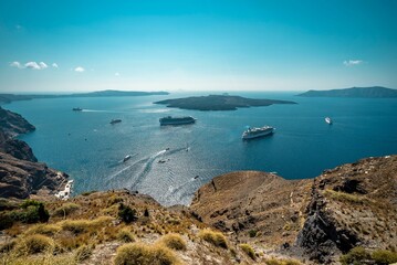 Beautiful view of the blue sea with multiple ships and boats. Oia, Santorini, Greece.