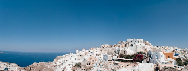 Panoramic view of Oia with its traditional white buildings. Santorini, Greece. - obrazy, fototapety, plakaty