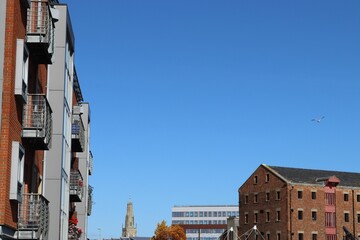 Tall buildings with balconies on a sunny day and the clock tower in the background