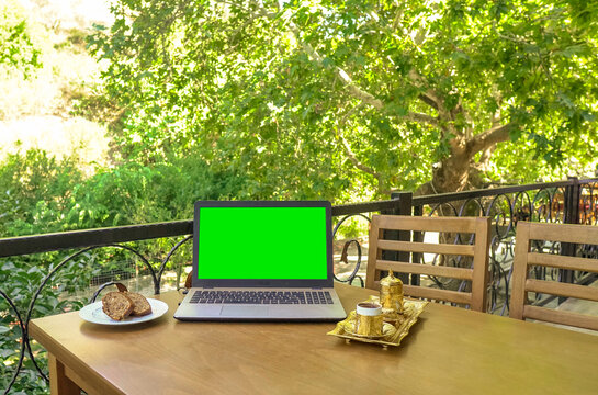 Working on the computer with coffee in nature - green screen v2