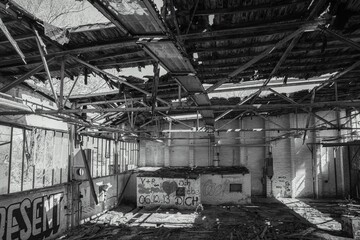 Greyscale of an abandoned building with graffiti adorning its walls
