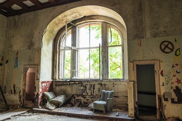 Abandoned room featuring an array of furniture and a window alongside the walls
