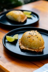 a close up of two black plates of food on a wooden table