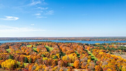 Aerial view of an autumnal scene of trees on the banks of a Cut River, in Michigan