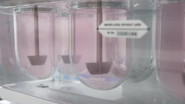 tablet dissolution test apparatus working condition close up. a scientific instrument dissolving tablets in a science instrumentation chemistry laboratory	

