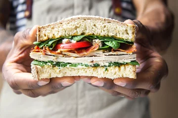 Rucksack man holding a sandwich with turkey and spinach © studioworkstock