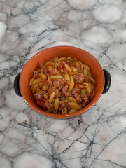 malloreddus or Sardinian gnocchetti, typical Sardinian pasta, with wild boar sauce, basil and pecorino cheese.