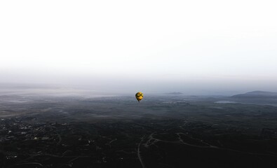 Distant hot air balloon soaring over a sprawling city skyline
