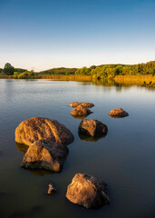sunset over the lake with large rocks
