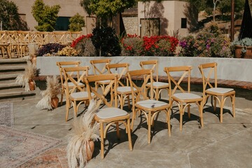 Beautiful outdoor ceremony set up with elegant chairs, and delicate pampas grass.
