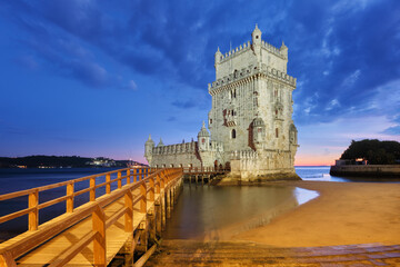 Belem Tower or Tower of St Vincent - famous tourist landmark of Lisboa and tourism attraction - on the bank of the Tagus River (Tejo) after sunset in dusk twilight with dramatic sky. Lisbon, Portugal - 768813237