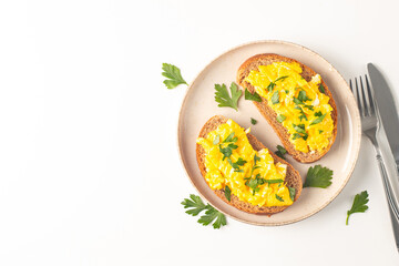 Scrambled eggs with green herbs on wheat-rye crispy toast.