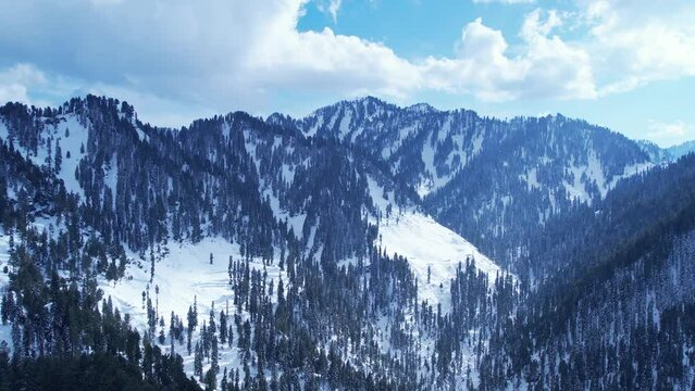 Aerial view of snow covered Himalayan mountains and pine forest in Malam Jabba