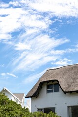 Fototapeta na wymiar Vertical of an old rural house under a cloudy blue sky