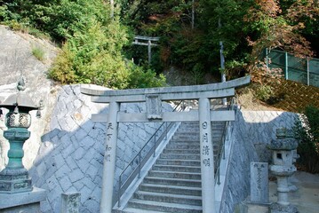 there is a large stone gate and stairs to the shrine