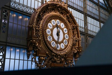 the old clock stands inside of the building, as it appears to be in front
