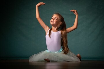 Smiling young girl in a dress performing a gymnastic pose.