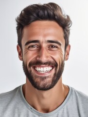 A portrait of a smiling man with a beard and white teeth
