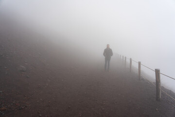 wooden handrail on a day of intense fog, pedestrian path to the top of the volcano mount vesuvio....