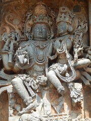 Fototapeta na wymiar Intricately carved stone statues of Hindu gods adorning the Hoysaleshwara Temple in Halebedu, India
