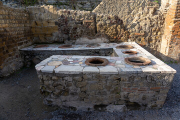 circular containers of ancient city thermopolium in Herculaneum archaeological park, Naples-...