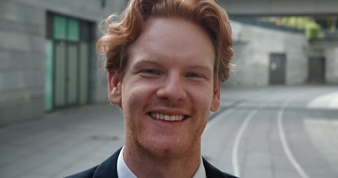 Redhead man in stylish suit smiles at camera face in close-up Smile symbol of positivity Smile radiates confidence lighting up features. Smile is blend of joy and self-assurance is clearly visible.